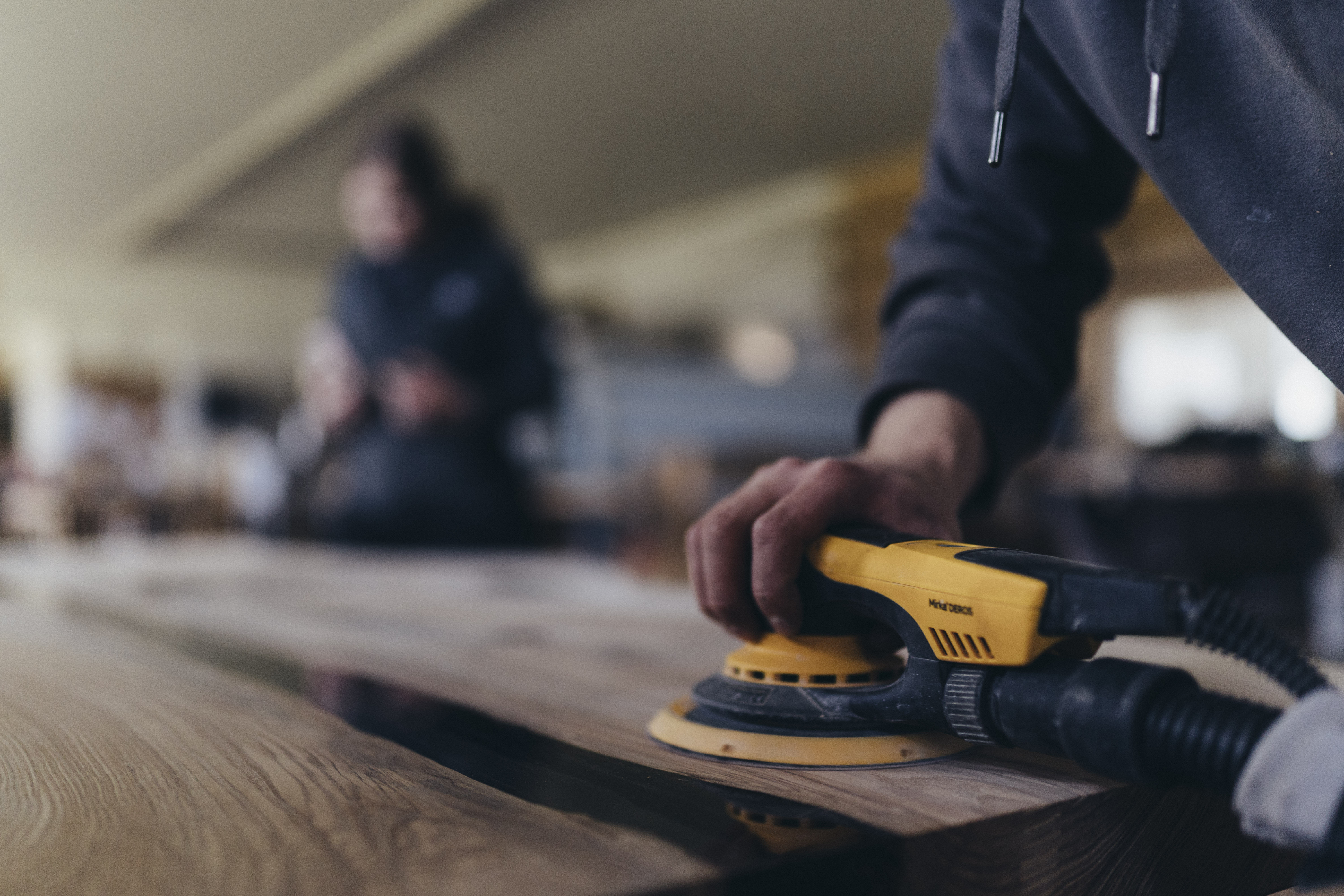 Handwerkliche Bearbeitung einer massiven Tischplatte in der Werkstatt